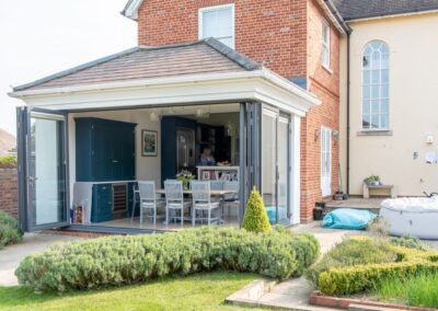 Origin cornerless aluminium bifold doors open to garden, Essex installation