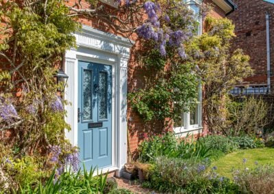 Front elevation of an Edwardian-style Essex property with Bereco timber sash windows and Wisteria in bloom